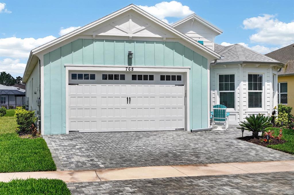A light blue house with a white garage door and a paved driveway — 768 MARGARITAVILLE AVENUE, DAYTONA BEACH, FL