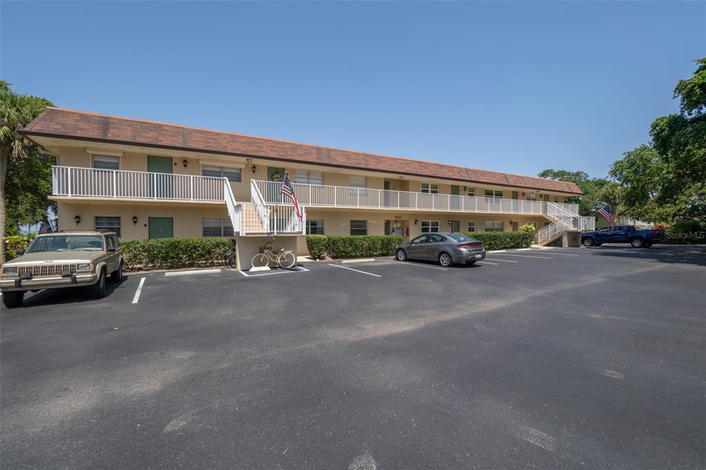 A two-story apartment building with a parking lot, exterior stairs, and a balcony — 6500 FALCON WAY UNIT 19D, CAPE CANAVERAL, FL