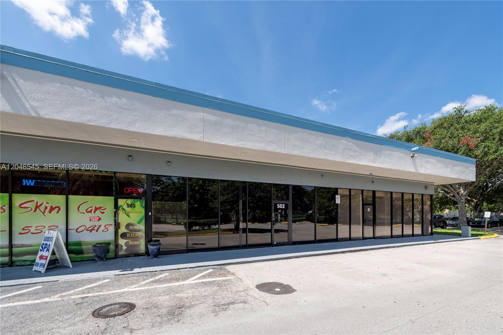A commercial building exterior features a row of glass storefronts under a flat roof — 3801 N University Dr # 501, Sunrise FL 33351, SUNRISE, FL