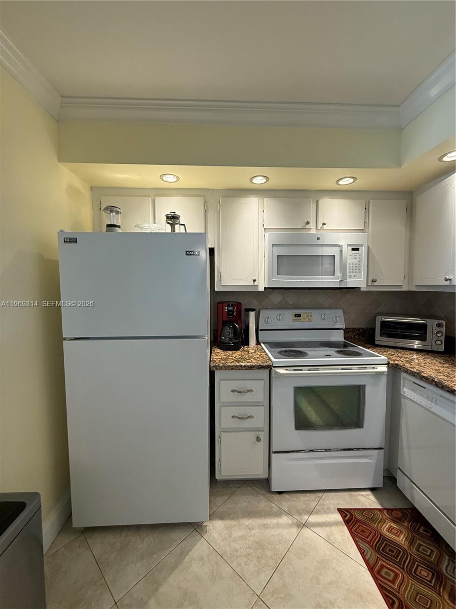 A kitchen features white appliances, granite countertops, and white cabinetry — 127 Tuscany B # 127, Delray Beach FL 33446, DELRAY BEACH, FL