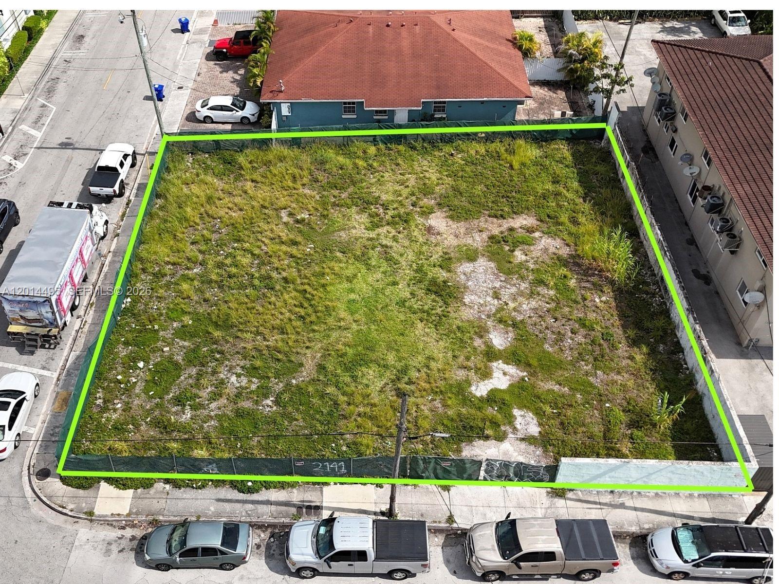 An aerial view shows a vacant, fenced-in rectangular lot situated between a house and building — 2141 SW 3rd St, Miami FL 33135, MIAMI, FL