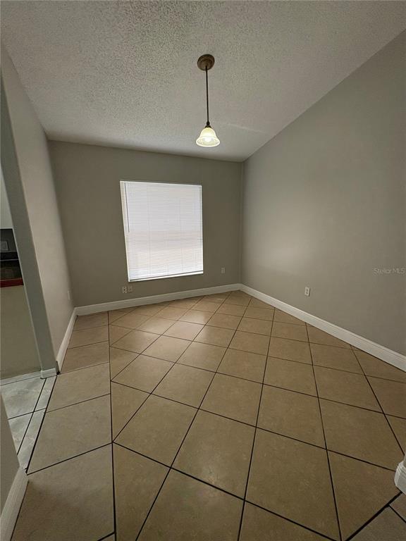 A living room features light-colored tile flooring, a ceiling fan, and a sliding glass door — 305 COLONADE COURT, KISSIMMEE, FL