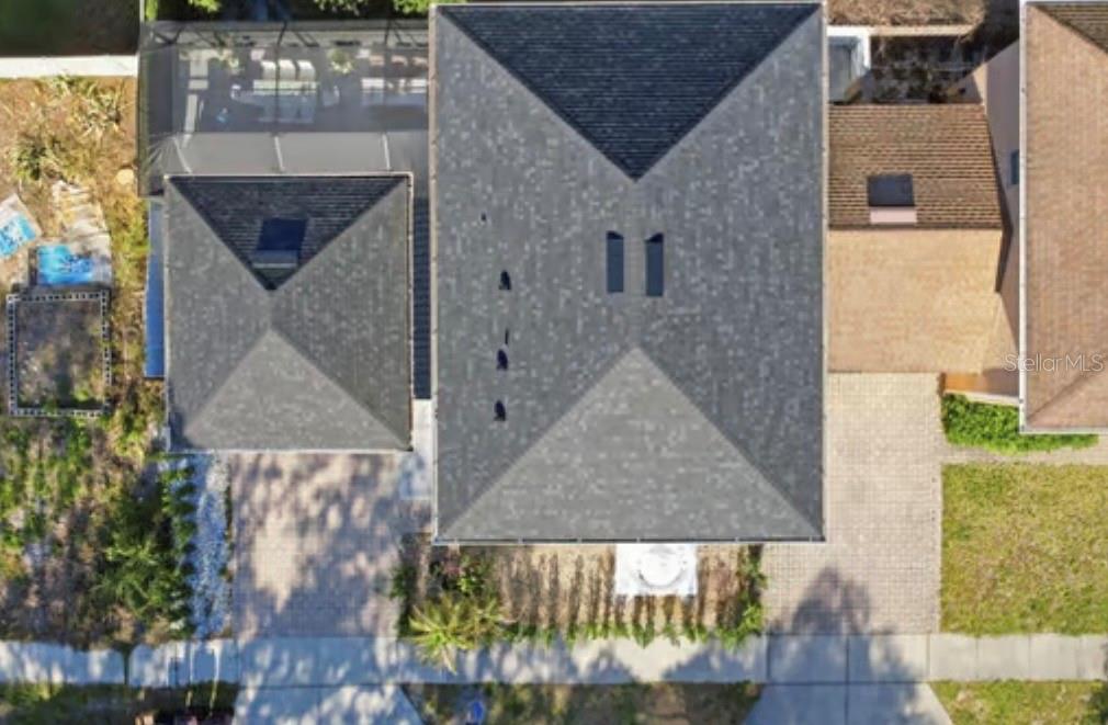 An aerial view shows the shingled roofs of a house and an adjacent screened-in patio — 1046 MORRIS AVENUE UNIT 1046, ORLANDO, FL