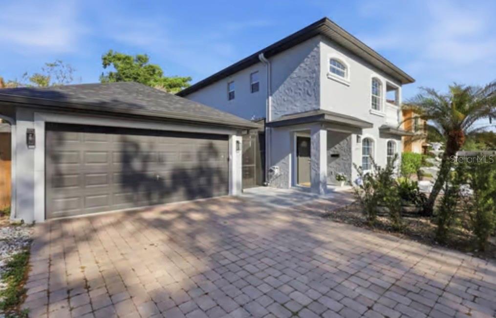 A two-story house with a gray exterior, stone accents, and a paved driveway — 1046 MORRIS AVENUE UNIT 1046, ORLANDO, FL
