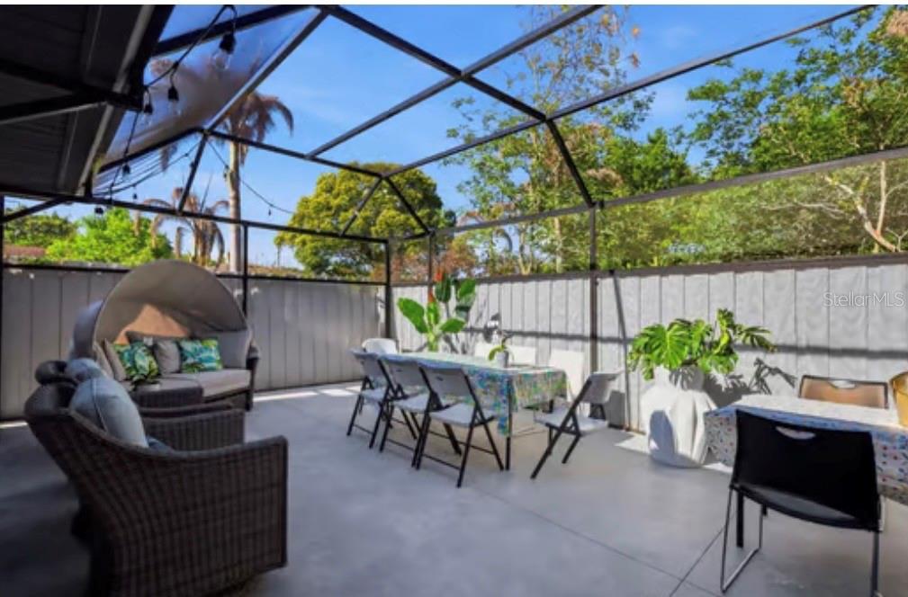 A screened-in patio features outdoor furniture, a dining table, and a concrete floor — 1046 MORRIS AVENUE UNIT 1046, ORLANDO, FL