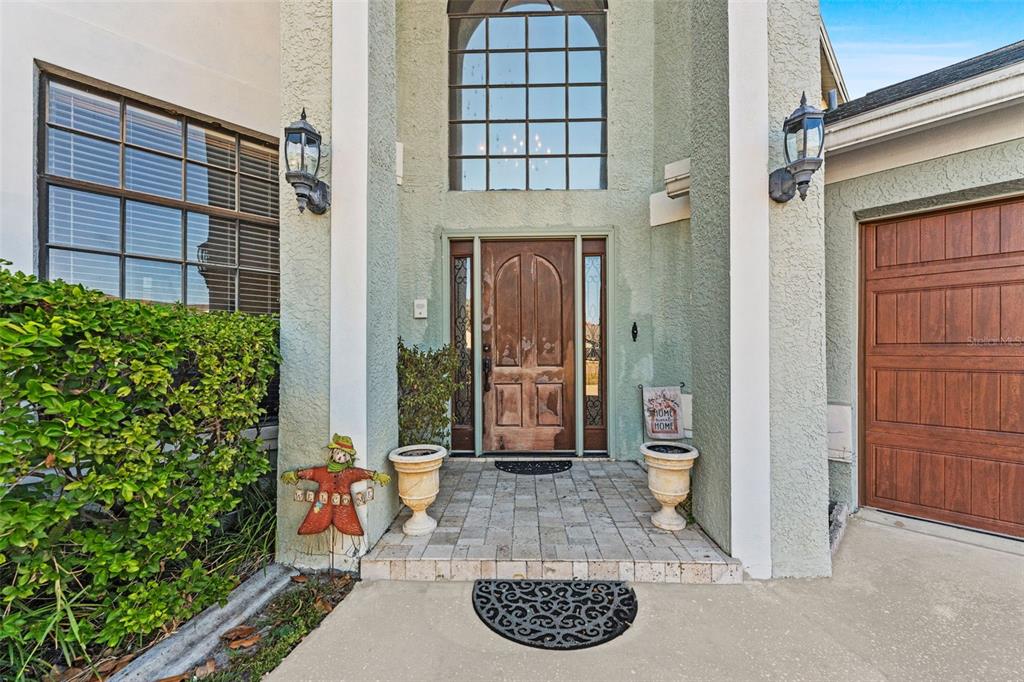 The exterior entrance features a wooden front door, arched window, and a paved porch area — 11429 ZENITH CIRCLE, TAMPA, FL