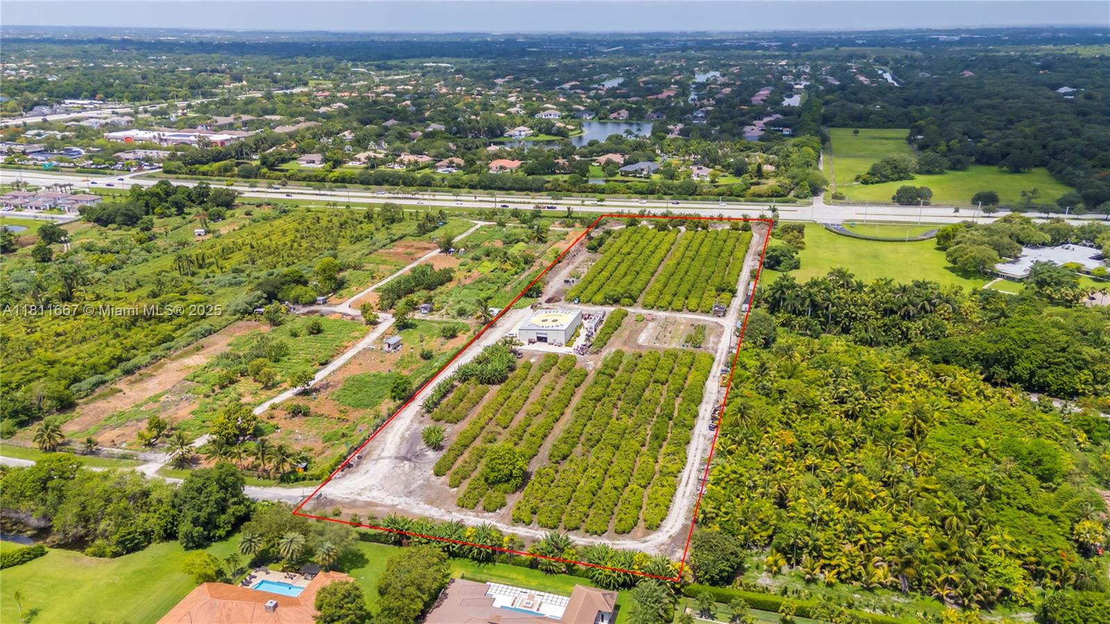 An aerial view shows a rectangular agricultural plot with rows of trees and a building — 4077 SW 121st Ter, Davie FL 33330, DAVIE, FL