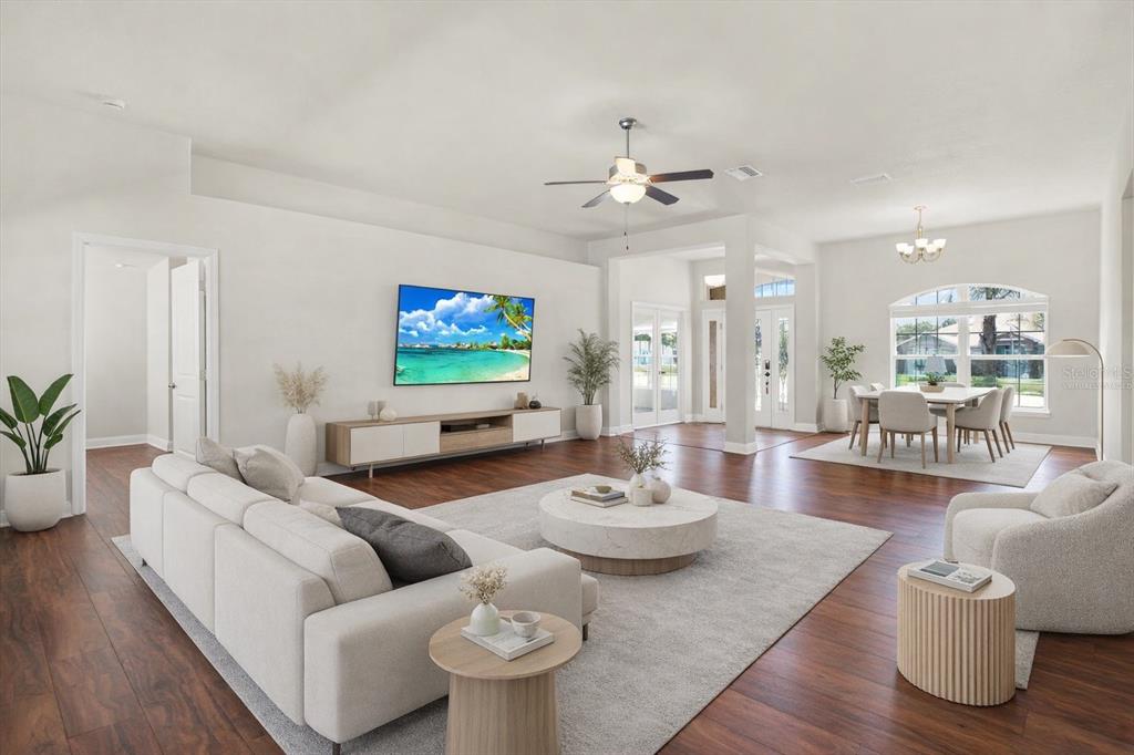 A bright, open-concept living and dining area features white walls, dark wood floors, and modern furniture — 14061 WHITE PLAINS STREET, SPRING HILL, FL