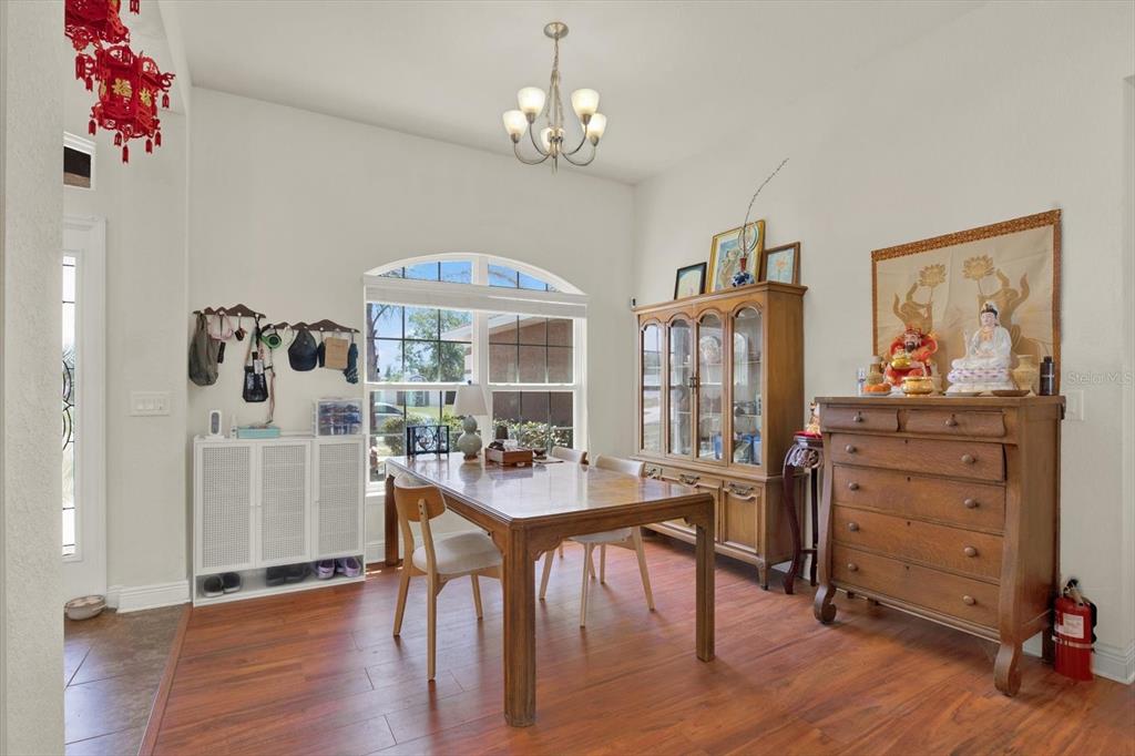 A dining room features wood flooring, a wooden table, a hutch, and a chest — 14061 WHITE PLAINS STREET, SPRING HILL, FL