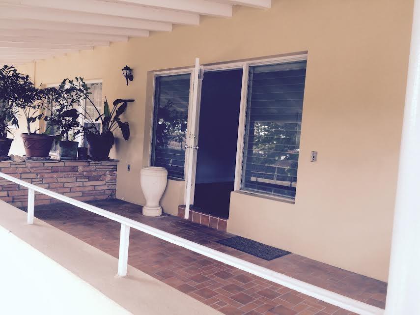 A covered patio features a brick planter, potted plants, a white pedestal, and glass windows — 30 Park Drive # 15, Bal Harbour FL 33154, BAL HARBOUR, FL
