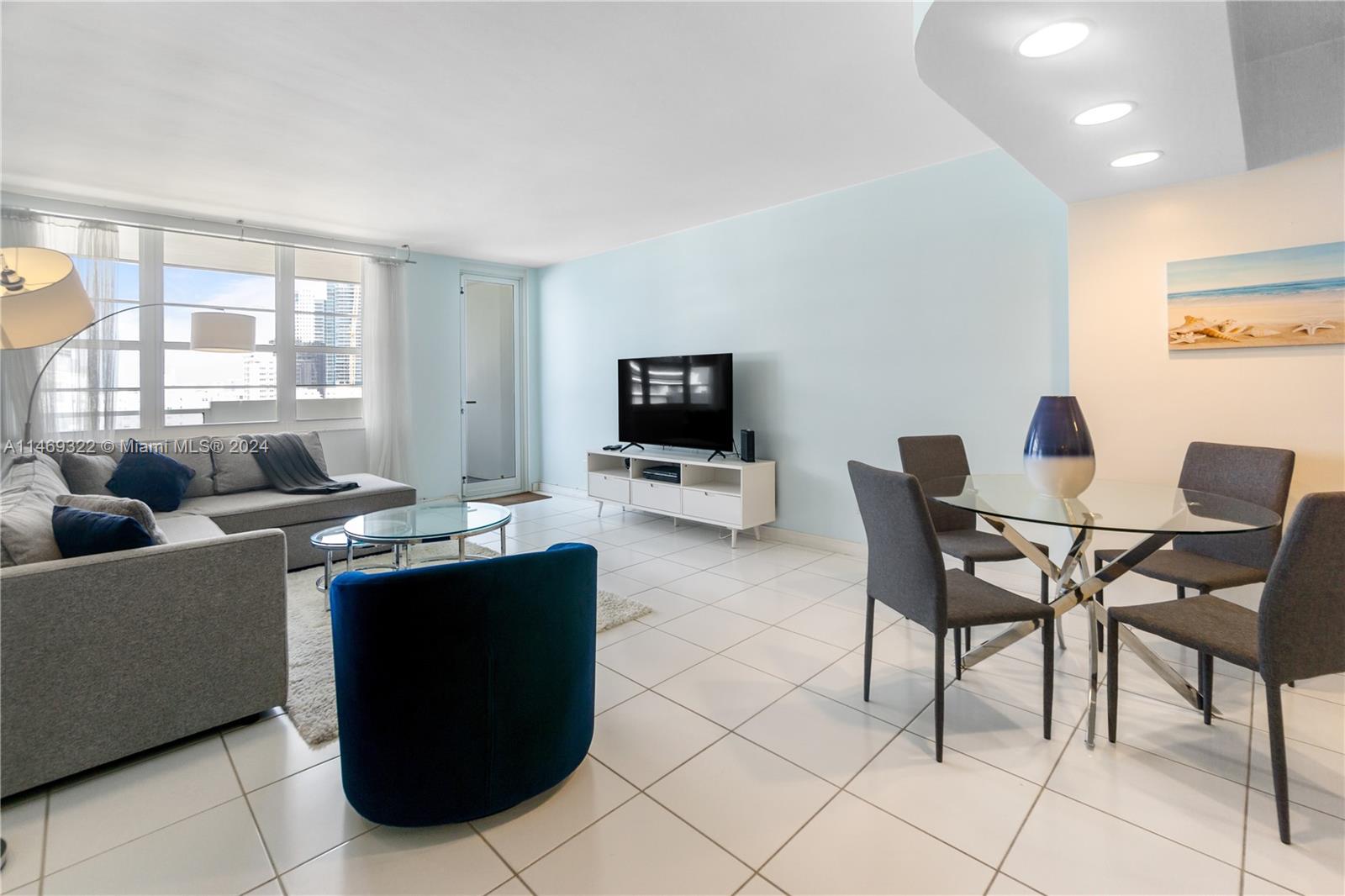 A living and dining area features light blue walls, white tile floors, and modern furniture — 100 Lincoln Rd # 1043, Miami Beach FL 33139, MIAMI BEACH, FL