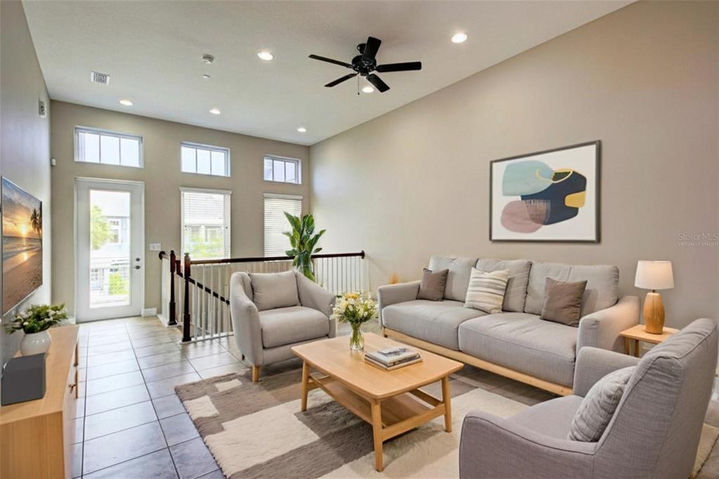 A living room with high ceilings, a ceiling fan, tile flooring, and neutral furniture — 13851 SCHROCK AVENUE, ORLANDO, FL