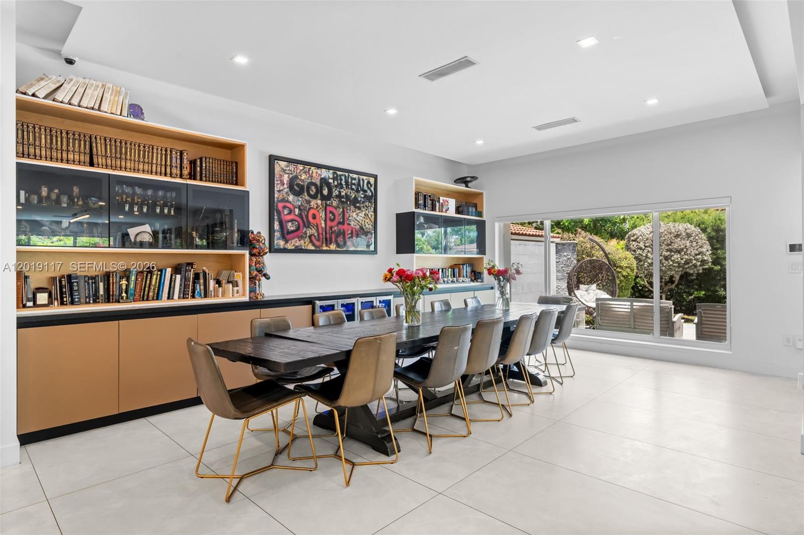 A dining room features a long dark wood table, gold-legged chairs, and built-in shelving — 3748 Prairie Ave, Miami Beach FL 33140, MIAMI BEACH, FL