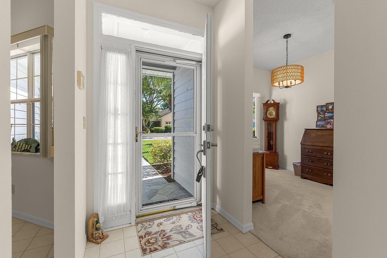 An entryway features a white front door, a screen door, and a view into a room — 431 Tamarind Place, Vero Beach FL 32962, VERO BEACH, FL