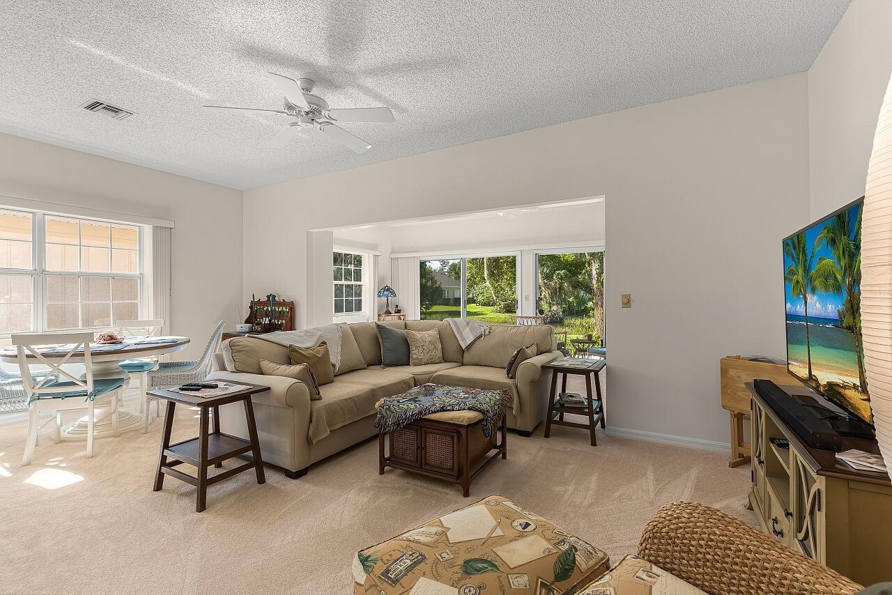 A living room with a beige sectional sofa, a ceiling fan, and a television — 431 Tamarind Place, Vero Beach FL 32962, VERO BEACH, FL