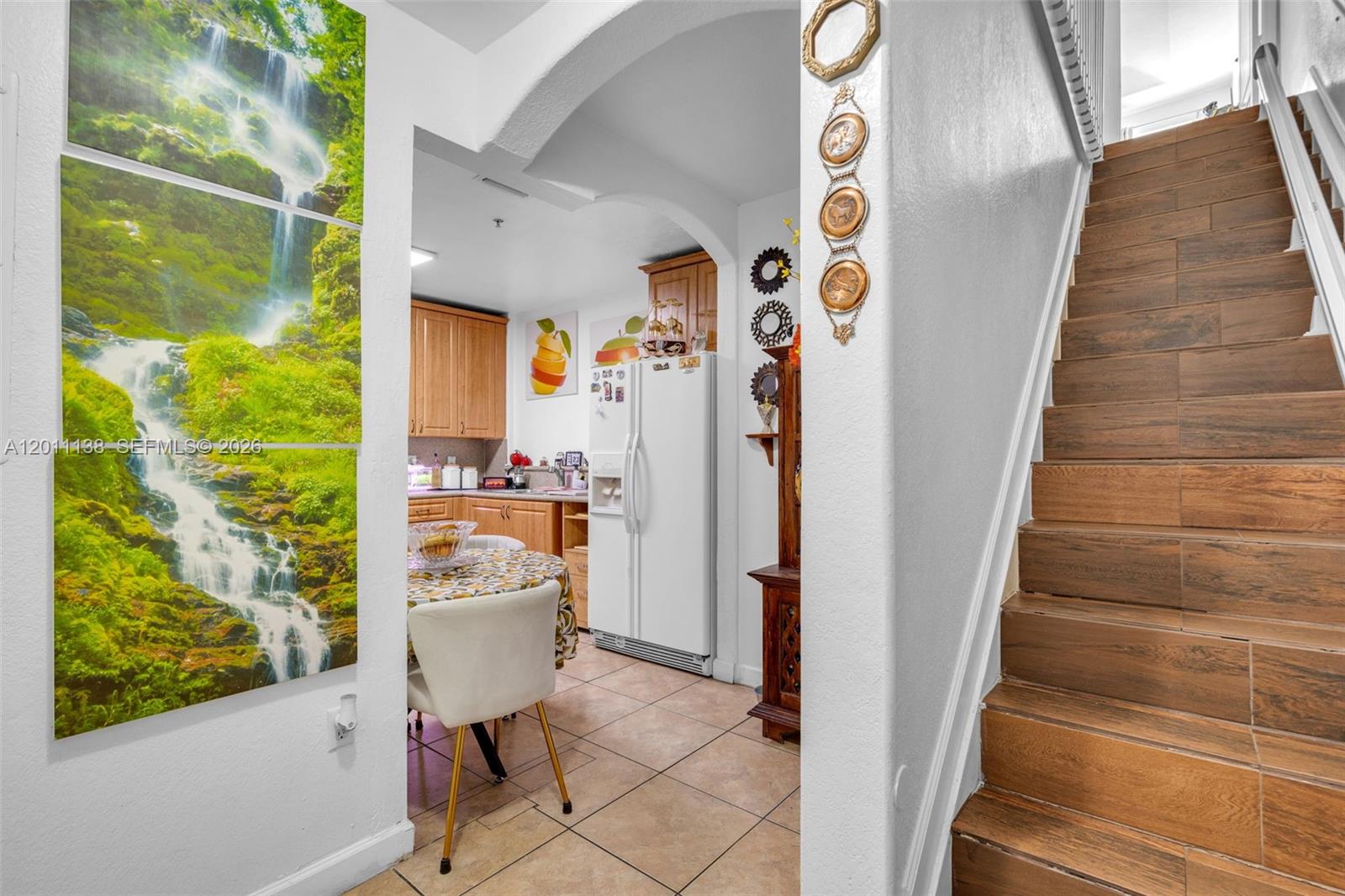 A view from a tiled staircase looking into a kitchen with light wood cabinets — 8031 W 36th Ave # 1, Hialeah FL 33018, HIALEAH, FL