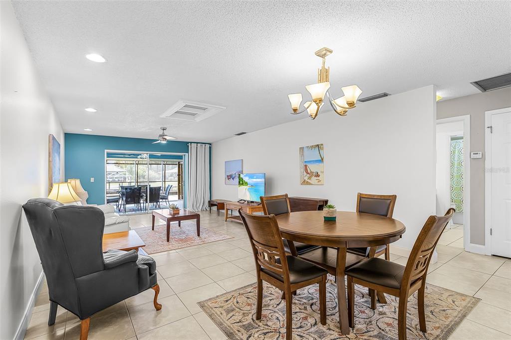 A dining area with a wooden table and chairs sits in front of a living room — 4504 SE 6TH PLACE UNIT A+B, CAPE CORAL, FL
