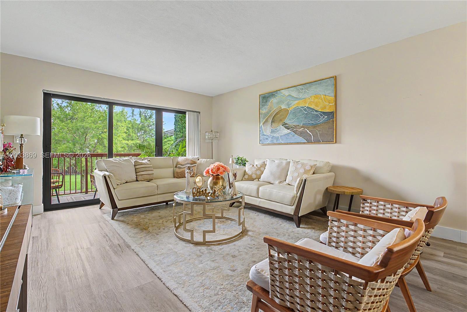 A living room features two cream sofas, a glass coffee table, and two woven chairs — 10227 NW 9th St Cir # 3, Miami FL 33172, MIAMI, FL