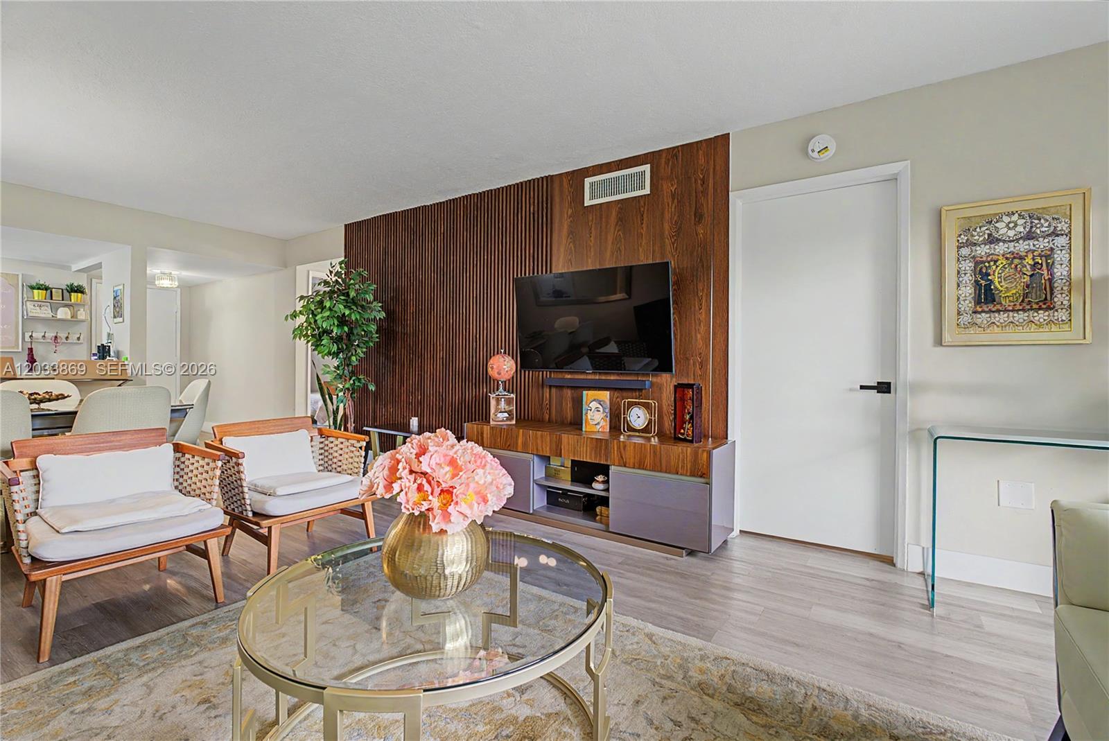 A living room features a wood-slatted accent wall, a television, and a glass coffee table — 10227 NW 9th St Cir # 3, Miami FL 33172, MIAMI, FL