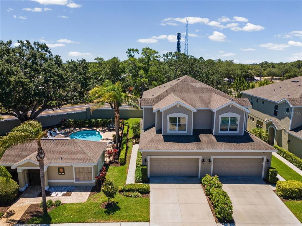 An aerial view shows a two-story house with a pool, a detached garage, and landscaping — 450 HARBOR SPRINGS DRIVE, PALM HARBOR, FL