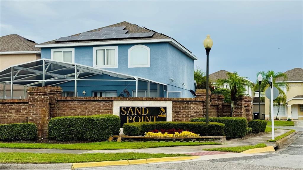 An open-concept living area features light tile flooring, a staircase, and a sliding glass door — 1203 SANDESTIN WAY, ORLANDO, FL