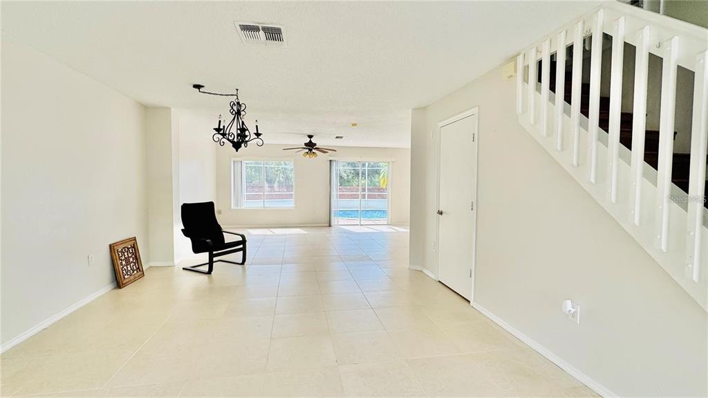 A kitchen with light cabinets and a pool view through a sliding glass door — 1203 SANDESTIN WAY, ORLANDO, FL