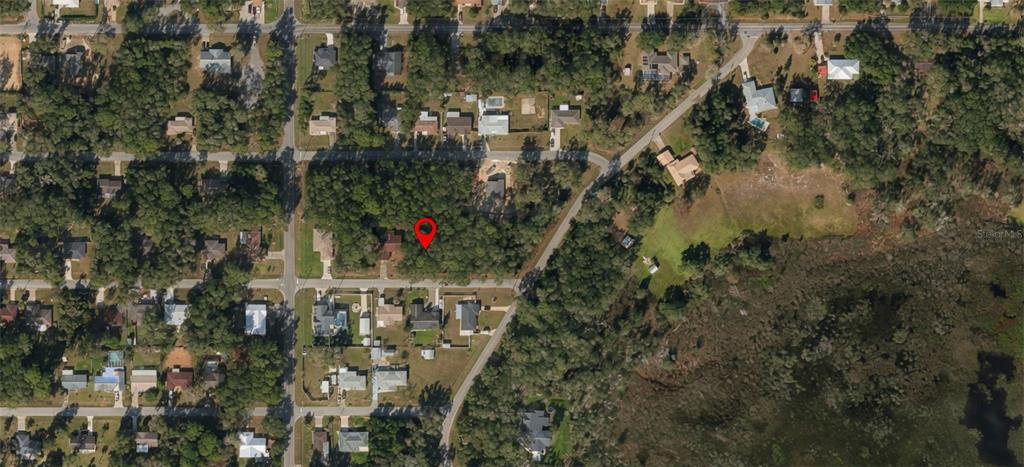 This is an aerial map view of a wooded residential lot marked with a pin — 6355 E PEACH STREET, INVERNESS, FL