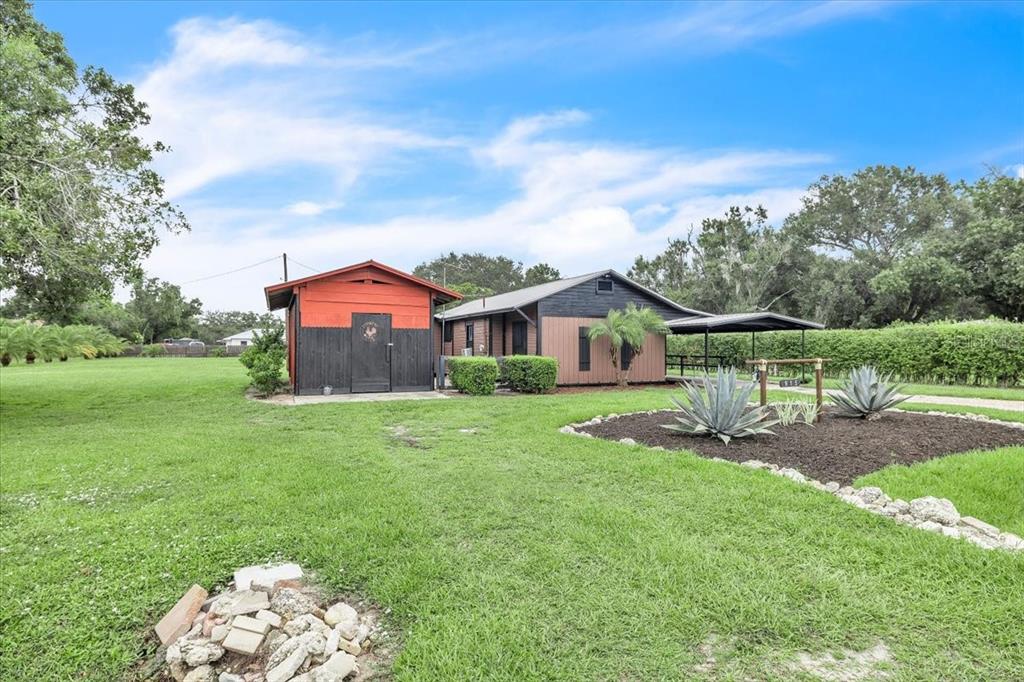 A single-story house with a red and black shed stands on a grassy lawn — 915 E CHARLES STREET, ARCADIA, FL