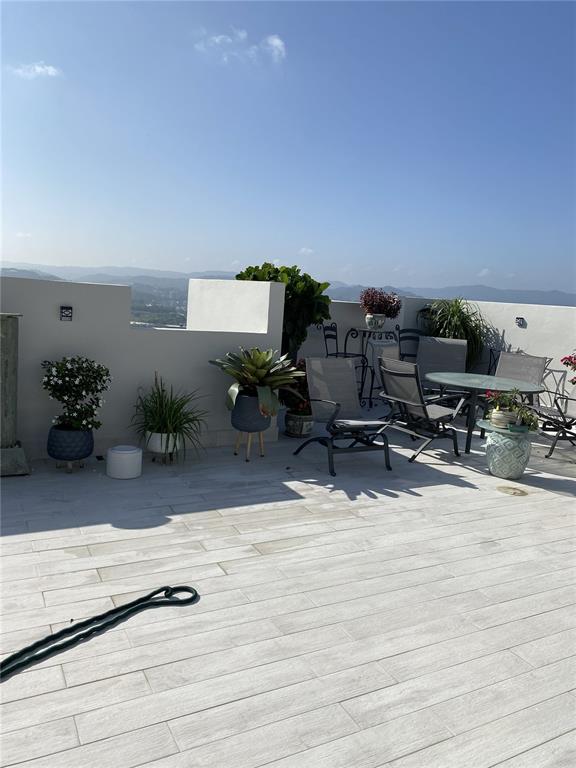 A spacious outdoor rooftop terrace features light-colored tile flooring, patio furniture, and potted plants — Carretera 833 PLAZA DEL PRADO UNIT 1304, GUAYNABO, PR