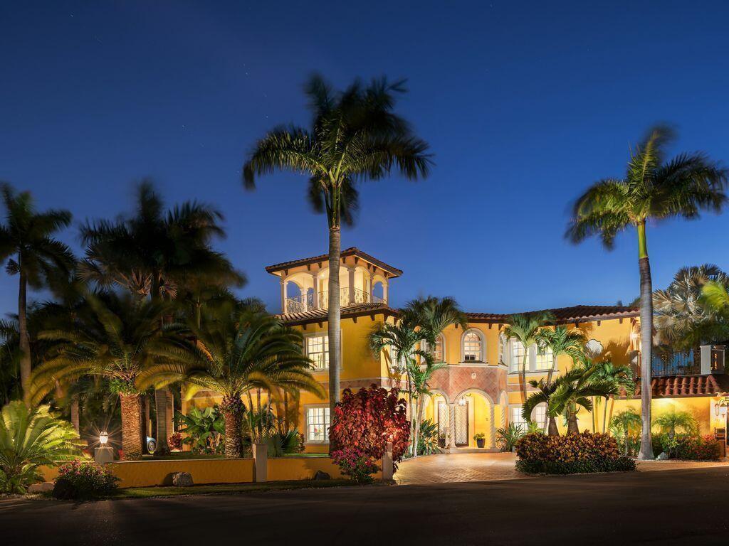 A yellow two-story Mediterranean-style house at night with palm trees and a paved driveway — 600 Circle Drive, Pompano Beach FL 33062, POMPANO BEACH, FL