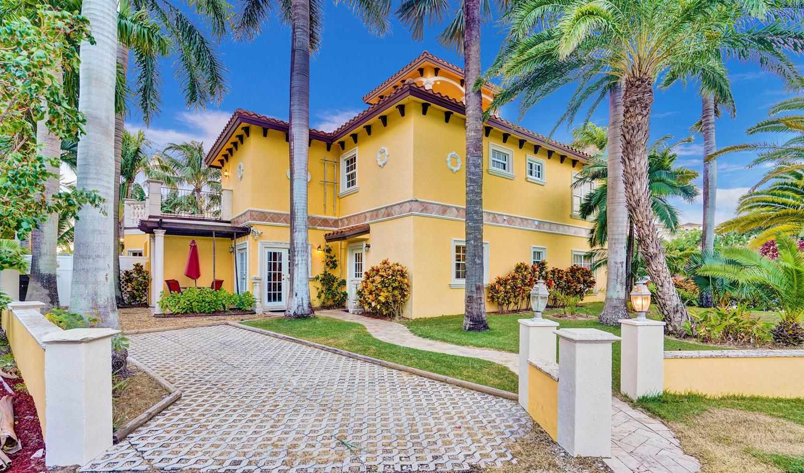 A two-story yellow stucco house with a tiled roof, palm trees, and a paved driveway — 600 Circle Drive, Pompano Beach FL 33062, POMPANO BEACH, FL