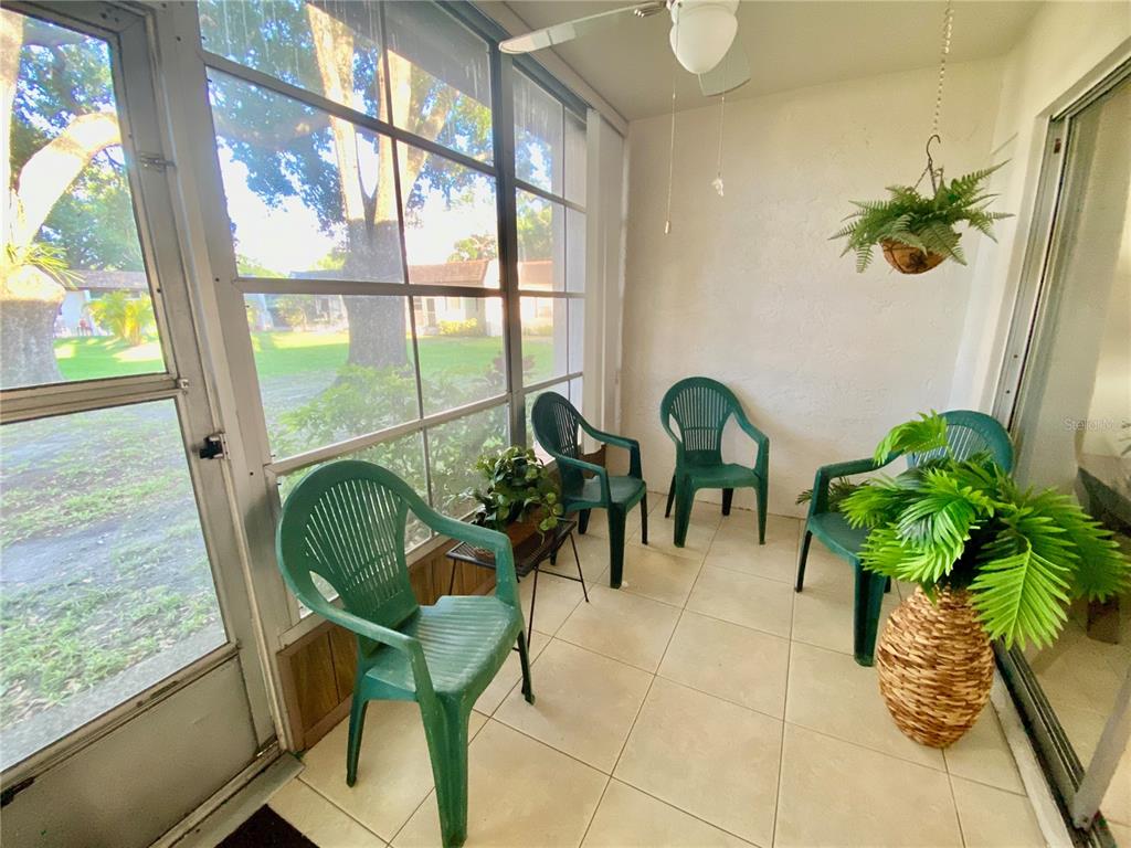 A dining area and living room with tile floors, a ceiling fan, and sliding glass doors — 3157 MISSION GROVE DRIVE, PALM HARBOR, FL