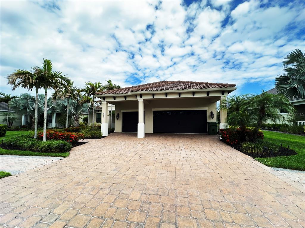 A single-story house with a tiled roof, a paver driveway, and a three-car garage — 540 REGATTA WAY, BRADENTON, FL