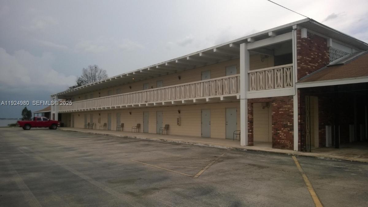 A two-story motel building with exterior walkways and a paved parking lot in front — 1001 LAKEVIEW DRIVE, Sebring FL 33870, SEBRING, FL