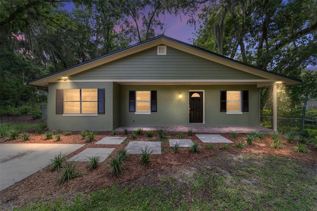A single-story house with green siding, dark shutters, and a concrete walkway at dusk — 755 SE 29TH TERRACE, OCALA, FL