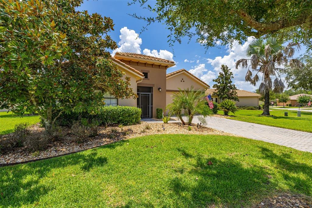 A tan single-story house with a tile roof, paved driveway, and landscaped front yard — 394 MONTEREY STREET, KISSIMMEE, FL