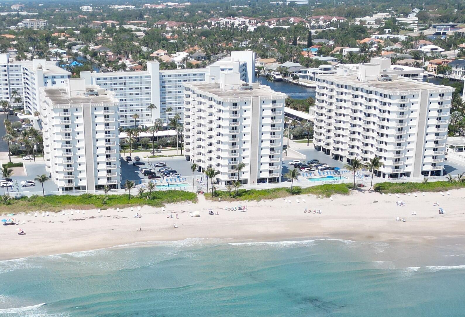 An aerial view of three white high-rise apartment buildings situated directly on a sandy beach — 3215 S Ocean Boulevard # 702, Highland Beach FL 33487, HIGHLAND BEACH, FL