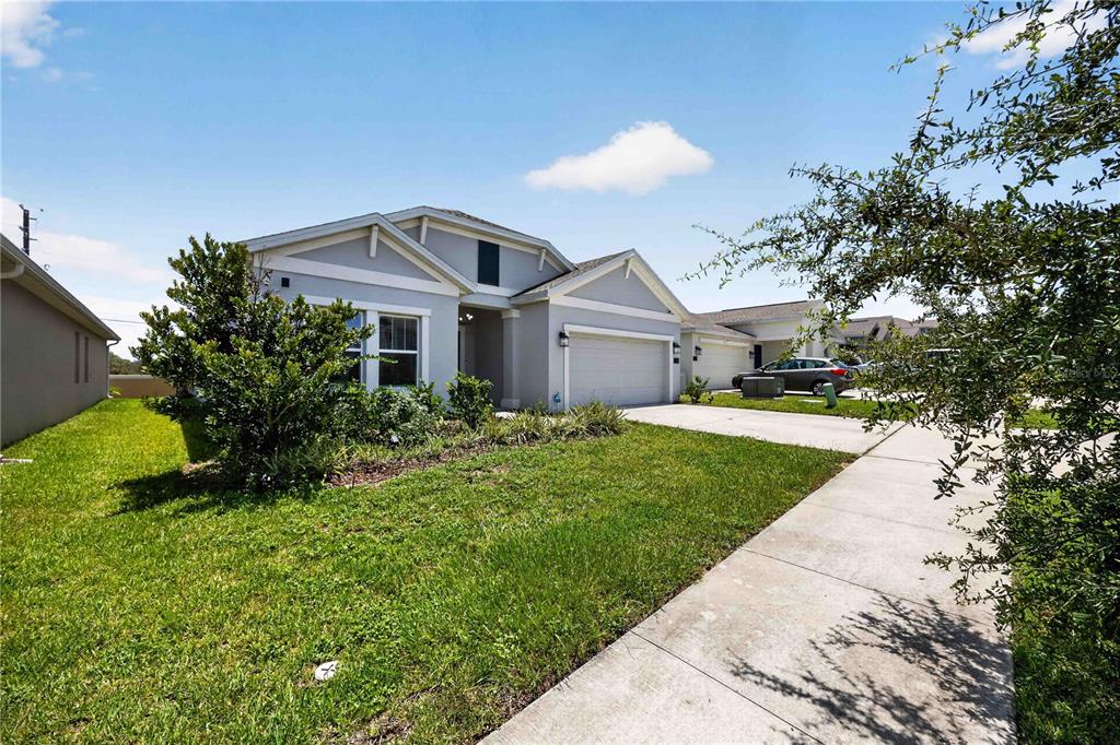 A single-story suburban house with a gray exterior, a two-car garage, and a front lawn — 281 PIAVE STREET, HAINES CITY, FL