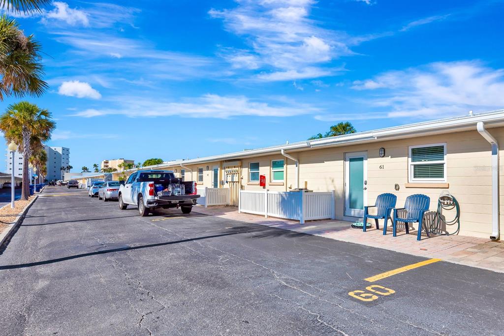 A paved driveway leads to a gated entrance of a low-rise building with palm trees — 5830 MIDNIGHT PASS ROAD UNIT 61, SARASOTA, FL