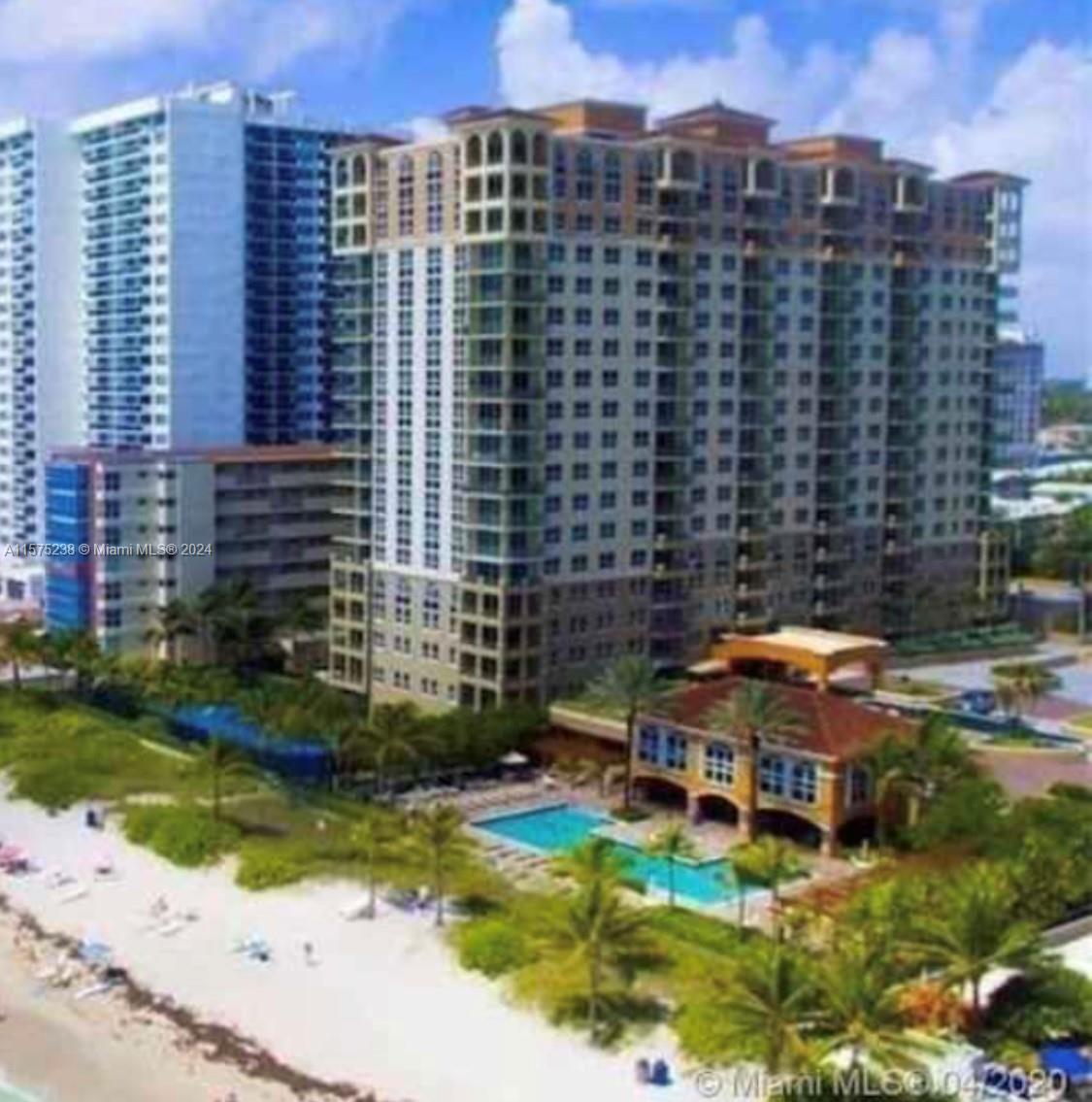 An exterior view of a multi-story residential building with a pool and beach access — 2080 S Ocean Dr # 401, Hallandale Beach FL 33009, HALLANDALE BEACH, FL