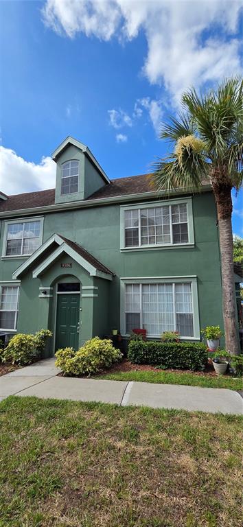 A two-story green exterior home with a palm tree and a front entrance — 9306 LAKE CHASE ISLAND WAY, TAMPA, FL