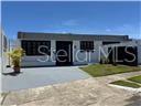 A single-story house with a flat roof, white exterior, and a paved front driveway — R88 CALLE 7, CAROLINA, PR