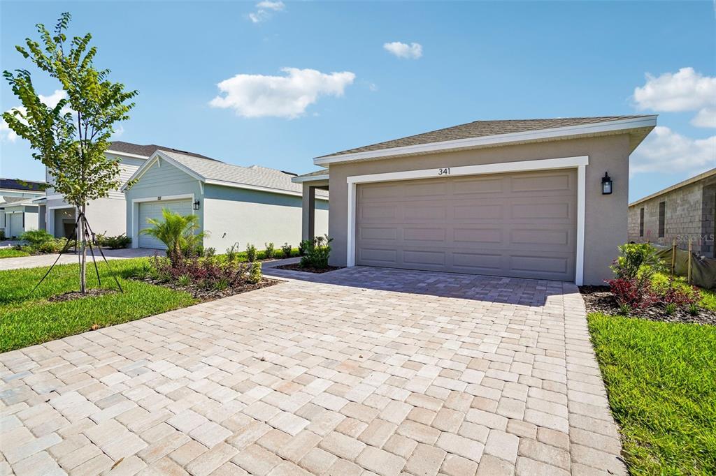 A beige single-story house with a paver driveway and a two-car garage — 341 MEREDITH BOULEVARD, WINTER HAVEN, FL