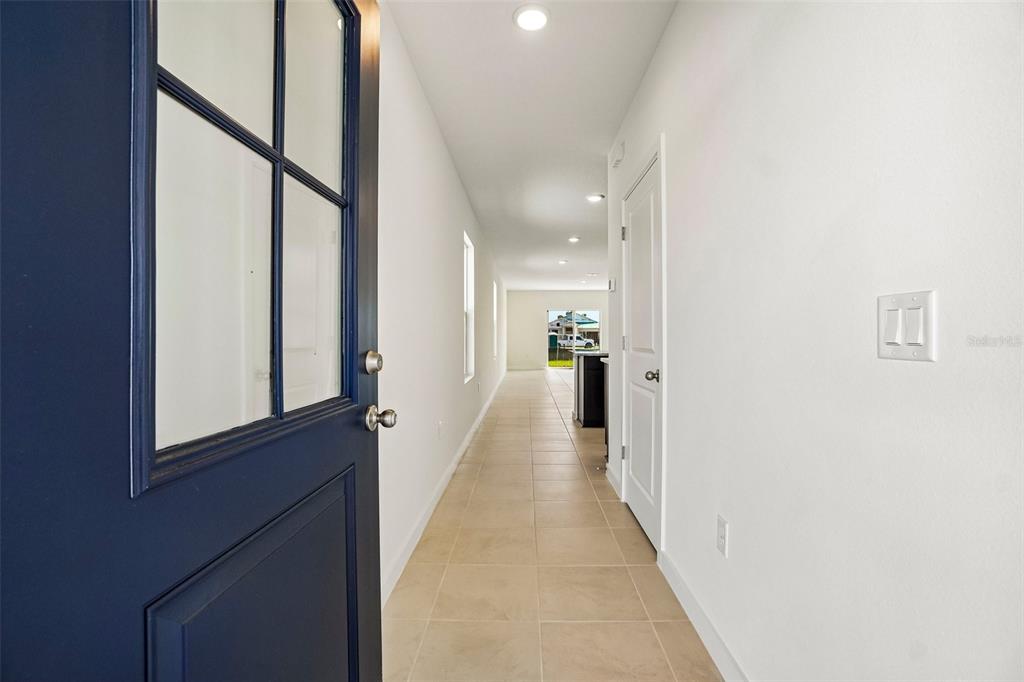 A view from an open blue door into a long hallway with tiled flooring — 341 MEREDITH BOULEVARD, WINTER HAVEN, FL