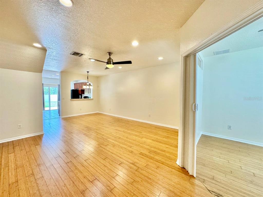 An interior view shows a living area with light wood flooring and a ceiling fan — 12381 FOXMOOR PEAK DRIVE, RIVERVIEW, FL