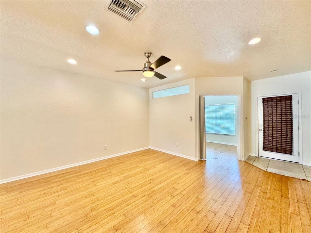 An empty room with light wood flooring, recessed lighting, a ceiling fan, and a doorway — 12381 FOXMOOR PEAK DRIVE, RIVERVIEW, FL