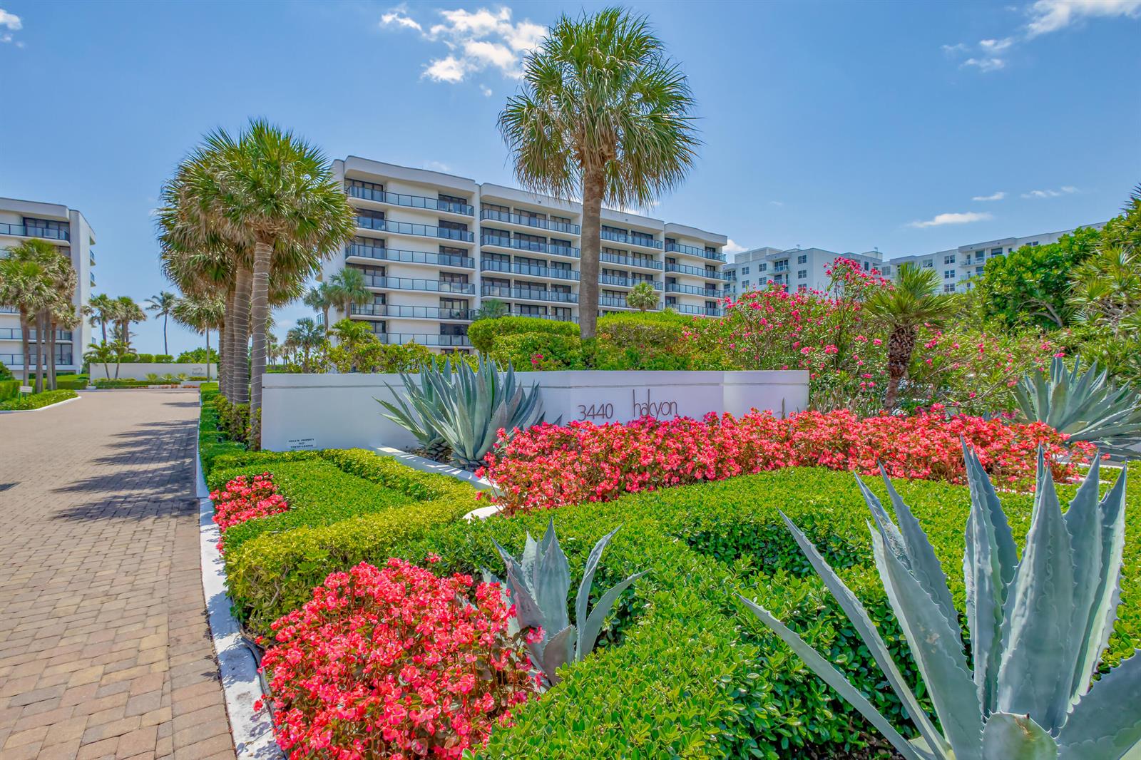A white building sign with the name Halcyon sits amidst lush landscaping and palm trees — 3440 S Ocean Boulevard S # 401, Palm Beach FL 33480, PALM BEACH, FL