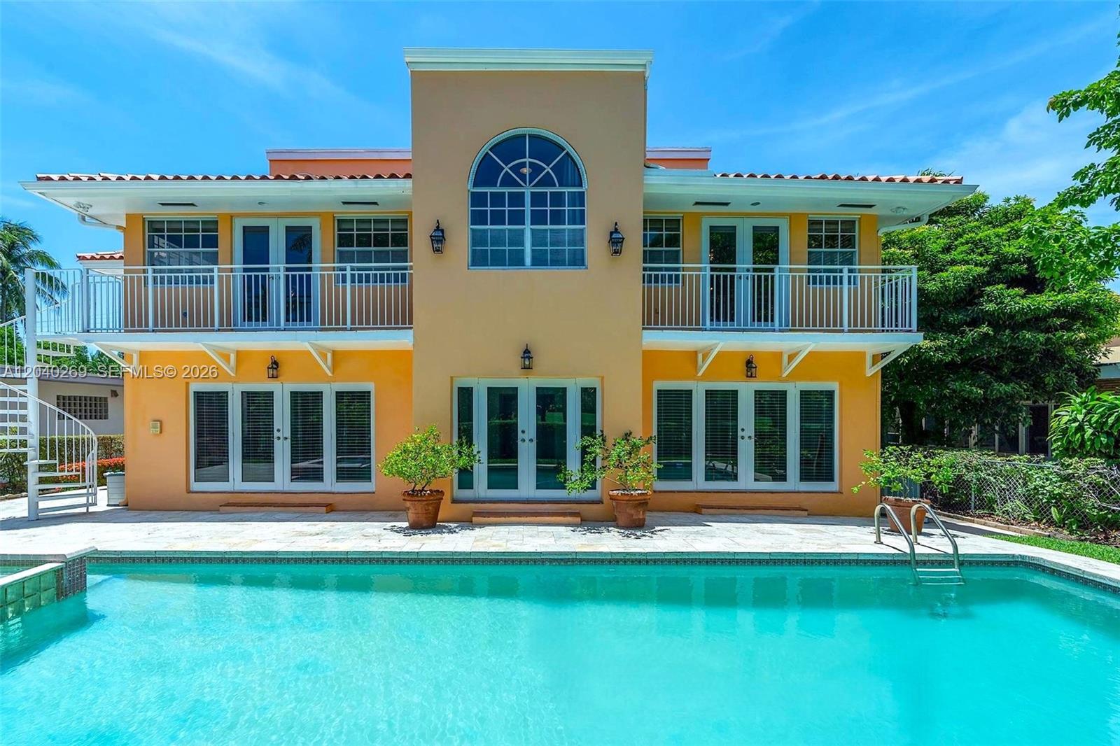 The exterior of a two-story house features a swimming pool, balconies, and multiple glass doors — 5309 Alton Rd, Miami Beach FL 33140, MIAMI BEACH, FL