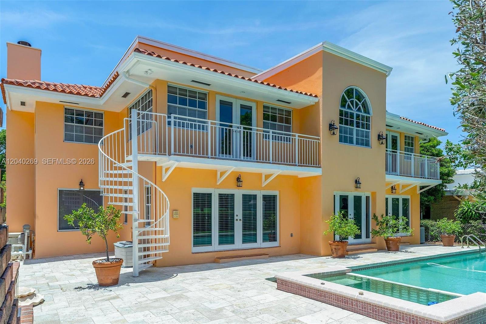 A two-story orange house features a white spiral staircase and a swimming pool — 5309 Alton Rd, Miami Beach FL 33140, MIAMI BEACH, FL