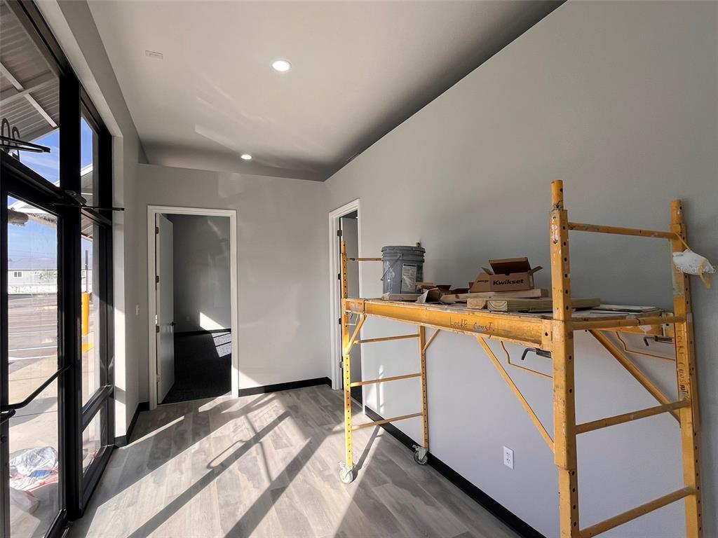 An interior view of a room with gray walls, wood-look flooring, and yellow scaffolding — 2019 21 STREET NW, WINTER HAVEN, FL